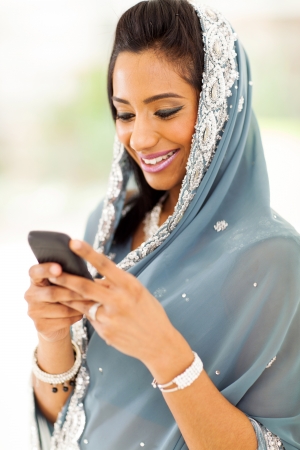 smiling indian woman in traditional clothes reading emails on smart phoneの写真素材