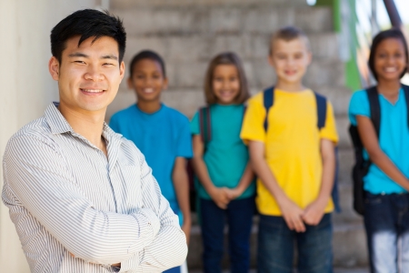 handsome male elementary educator with students on backgroundの写真素材