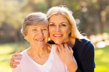 smiling senior woman and middle aged daughter outdoors closeup portrait