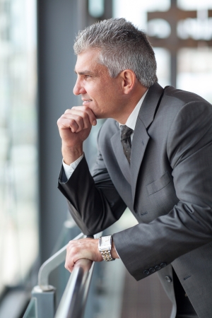 thoughtful senior businessman looking out the windowの写真素材