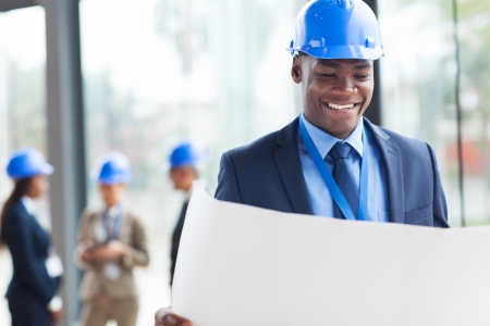 smart african construction businessman reading blue print