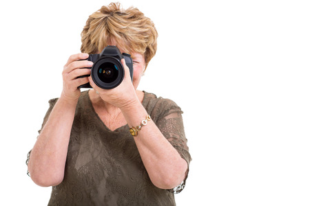 senior female amateur photographer taking photos isolated on whiteの写真素材