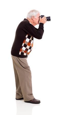 side view of elderly man shooting with digital SLR camera on white backgroundの写真素材