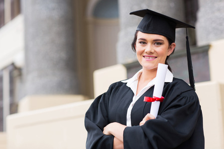 portrait of female college student holding graduation certificateの写真素材