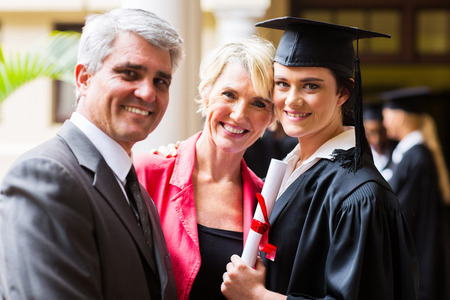 beautiful female college graduate with parents on graduation dayの写真素材