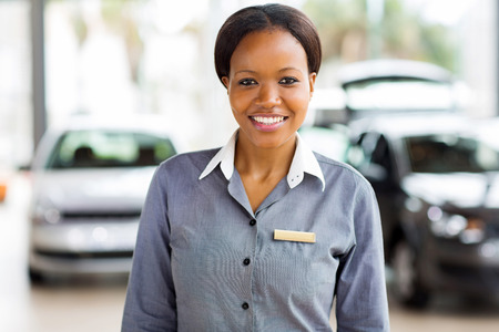 portrait of african american saleswoman standing at car dealershipの写真素材