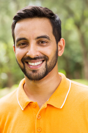 happy young indian man outdoors looking at the cameraの写真素材