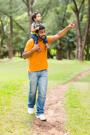 caring young indian father and son walking outdoors in forestの写真素材