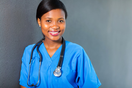 pretty young african medical intern standing against the wallの写真素材