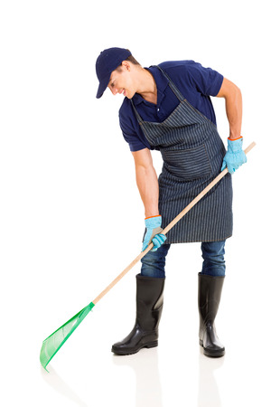 professional young gardener raking on white backgroundの写真素材