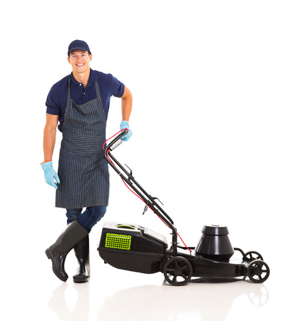 happy gardener standing next to a lawnmower isolated on whiteの写真素材