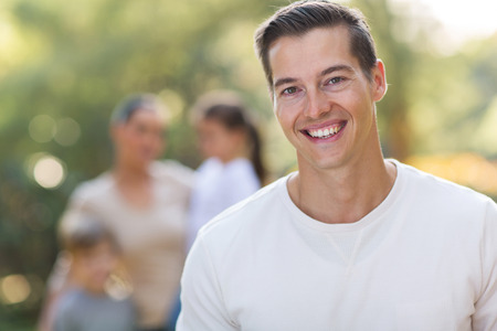 handsome young man standing in front of family outdoorsの写真素材