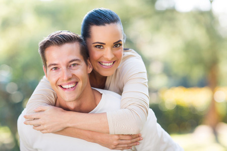attractive young couple piggybacking outdoorsの写真素材