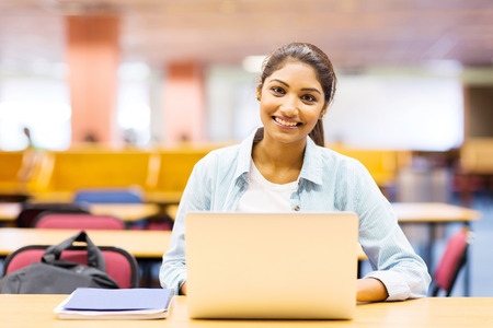 beautiful college girl using laptop in lecture hall