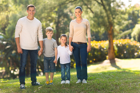 portrait of young family standing together outdoorsの写真素材