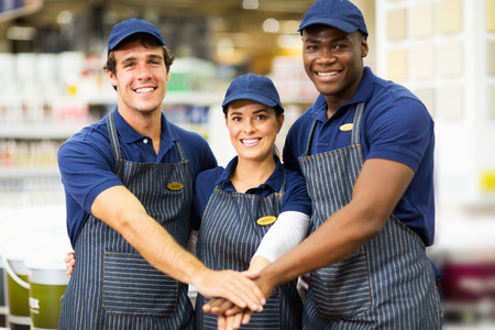 cheerful hardware team team putting their hands on top of each otherの写真素材