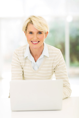 smiling middle aged businesswoman with laptopの写真素材