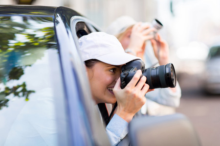 happy female tourist photographing the city from a carの写真素材