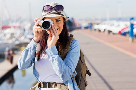 pretty tourist taking a photo at the harbourの写真素材