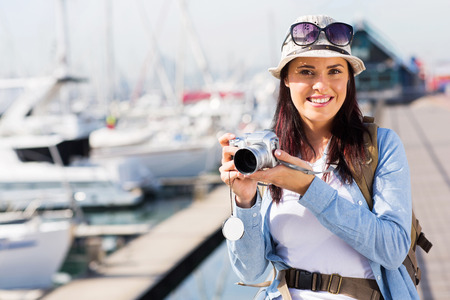 portrait of pretty female tourist standing at the harbour