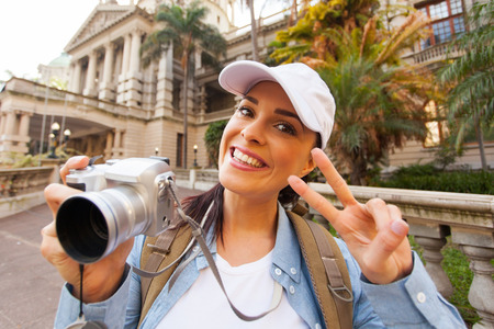 happy young traveller posing in front of an historical buildingの写真素材