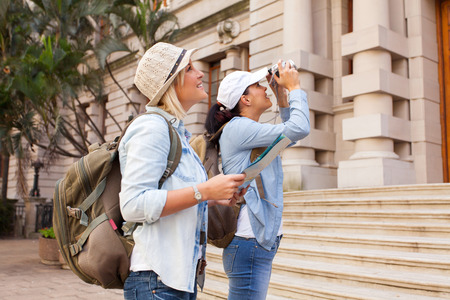 two tourists photographing an historical building in the cityの写真素材