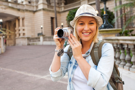 pretty tourist with camera in front of historical building の写真素材