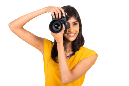 cheerful young indian woman taking pictures in studio with dslrの写真素材