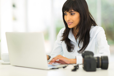 pretty female photographer working on computerの写真素材