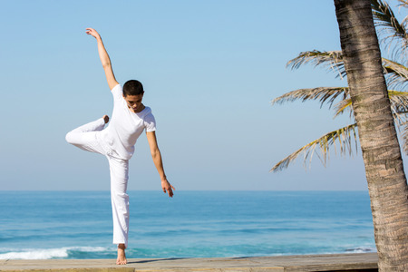 energetic young female dancer dancing on the beachの写真素材