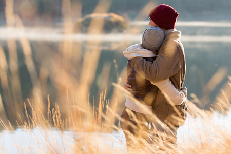 back view of lovely young couple hugging in winterの写真素材