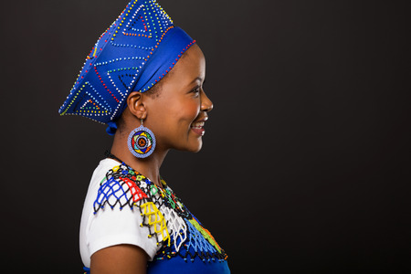 side view of young african zulu woman on black background