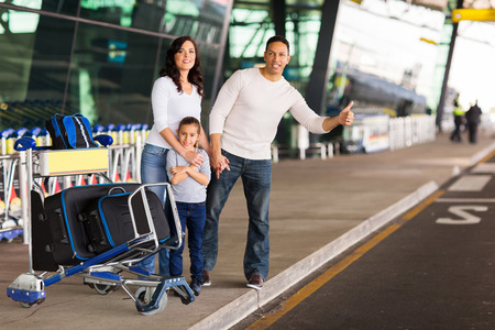 family hailing for a taxi after arriving at airportの写真素材