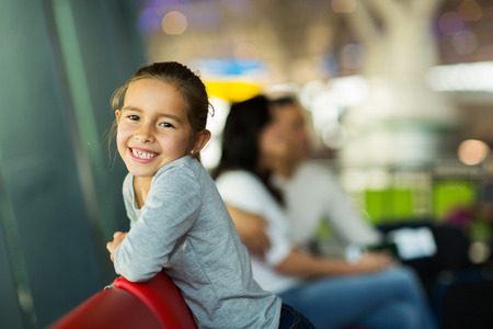 happy little girl with parents at airport waiting for flight の写真素材