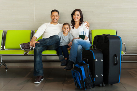 portrait of family with luggage waiting at airportの写真素材