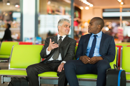 well dressed businessmen waiting for their flight at airportの写真素材