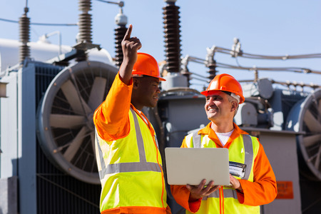 technical workers discussing work at electrical substationの写真素材