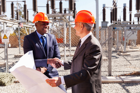 friendly business partners handshaking in electrical substation