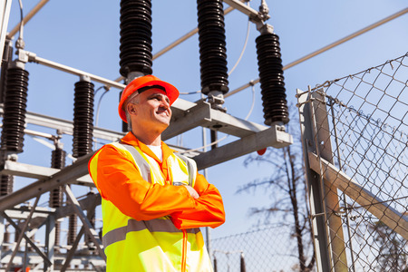 senior power plant technician with arms crossed in substation