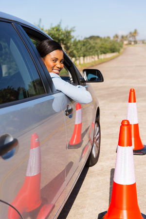 attractive african student driver taking driving lessons on testing groundの写真素材