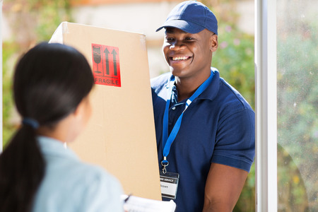 friendly young african american delivery man delivering a package friendly young african american delivery man delivering a package