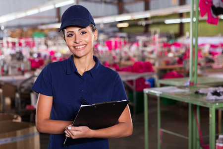 cheerful young clothing factory supervisor standing in production areaの写真素材