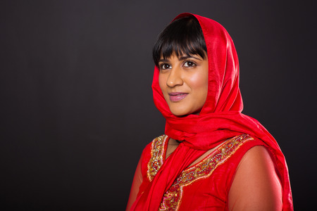 attractive indian woman looking away isolated on black backgroundの写真素材