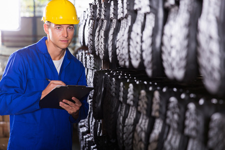 factory quality controller checking gumboots in warehouse