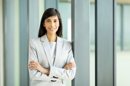 portrait of pretty young indian businesswoman with arms crossedの写真素材