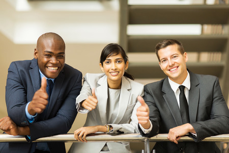 cheerful business group giving thumbs upの写真素材