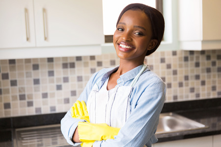 cheerful african woman standing in the kitchenの写真素材