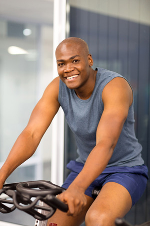 african american sitting on a stationary bike at the gym