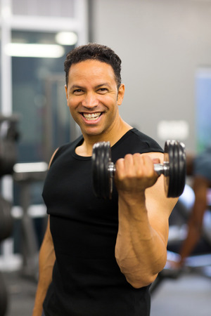 portrait of athletic man excising with dumbbellsの写真素材