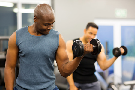 fit african american athlete lifting weights in gymの写真素材